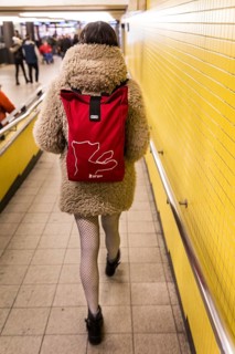 DEU Germany Germany Berlin A woman wears a Berlinale backpack with a plush coat and fishnet