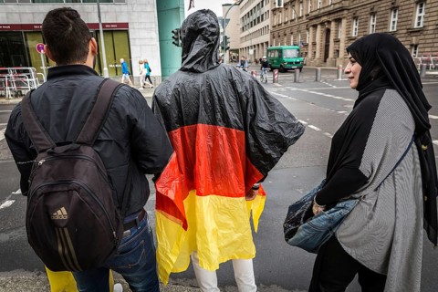 DEU Germany Germany Berlin Two tourists with rain capes in the colours of Germany are accompanied