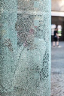 DEU Germany Germany Berlin Woman talking on the phone at a phone box with shattered glass in