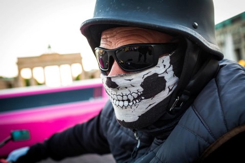 DEU Germany Germany Berlin A motorcyclist with a mask and sunglasses in front of the Brandenburg