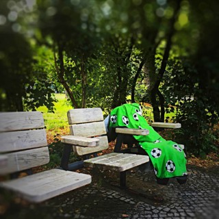 DEU Germany Germany Berlin A lonely blanket with football motifs lies abandoned on seats in a park