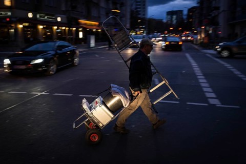 DEU Germany Germany Berlin A craftsman passes Nürnberger Straße in the evening with his tools