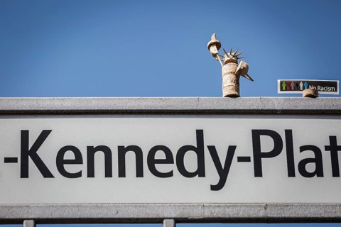 DEU Germany Germany Berlin A freedom statue made of cork stands on the street sign on J.F