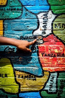 RWA RWANDA Rwanda Gahini A pupil shows Rwanda on a map of Africa painted on the wall