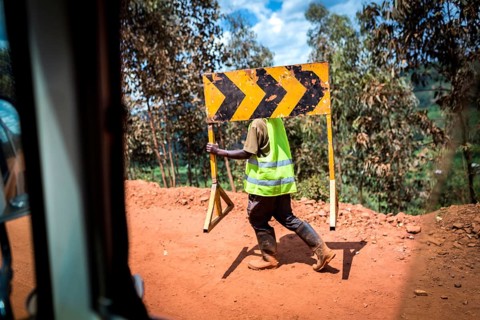 RWA RWANDA Rwanda Rusumo A worker carries a road sign across a construction site