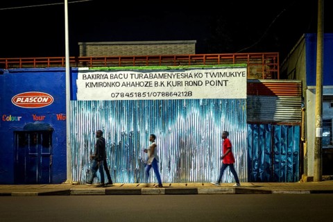 RWA RWANDA Rwanda Kigali people pass closed shops at night