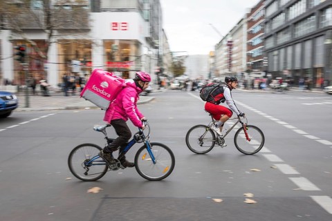 DEU Germany Germany Berlin A bicycle courier from Foodora starts off together with a cyclist at a