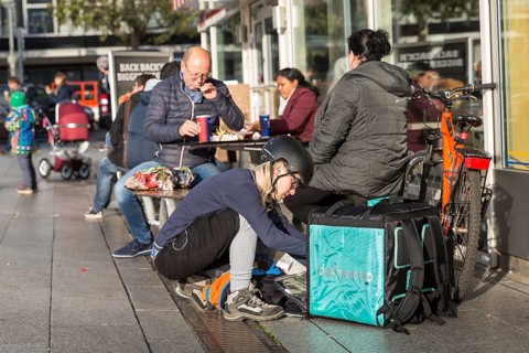DEU Germany Germany Berlin A bicycle courier packs his transport container with an order from a