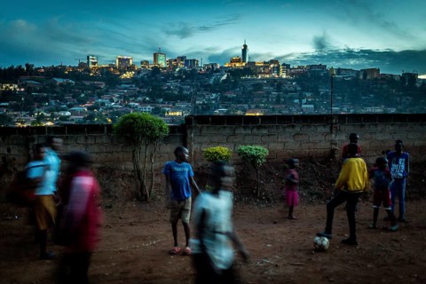 RWA RWANDA RUANDA Kigali Children playing football on a dusty path In the background, the Kiyovu