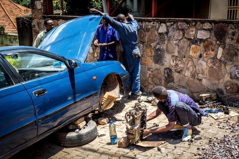 RWA RWANDA RUANDA Kigali Car mechanics dismantle the engine of a car on the street