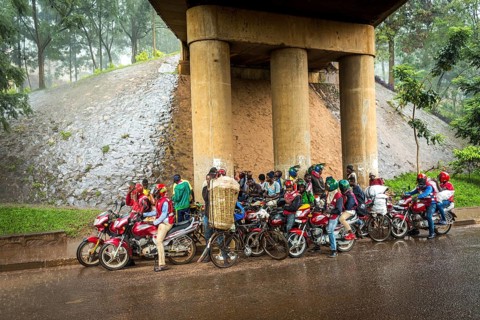 RWA RWANDA RUANDA Kigali Taxi drivers with motorbikes and bicycles wait under a bridge for the end