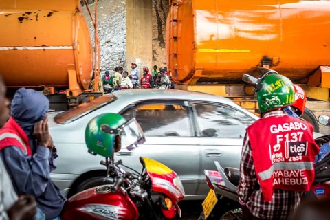 RWA RWANDA RUANDA Kigali Taxi drivers with motorbikes and bicycles wait under a bridge for the end