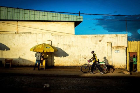 RWA RWANDA RUANDA Kigali A cyclist and a parasol cast their shadows on the wall
