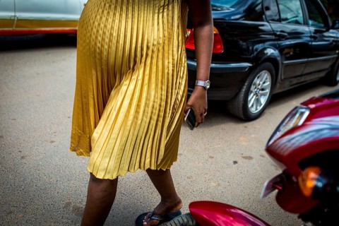 RWA RWANDA RUANDA Kigali A pregnant woman in a golden dress walks through the streets of Remera