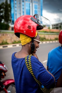 RWA RWANDA RUANDA Kigali A woman with a high hairstyle locks her helmet in front of taking a taxi