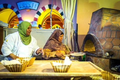 Egypt Hurghada Two elderly Egyptian women bake bread during an evening promotional event for