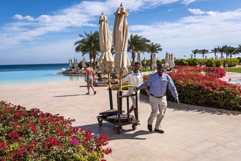 Egypt Hurghada Two hotel employees transport parasols