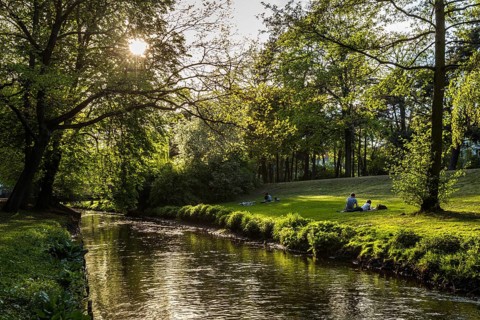 DEU Germany Germany Berlin People enjoying the sun on the banks of the Panke in Bürgerpark Pankow
