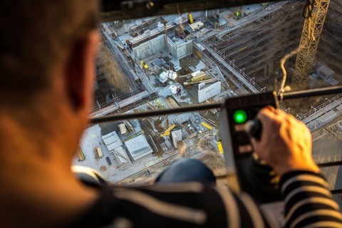 DEU Germany Germany Berlin A crane operator is transporting building materials on a construction