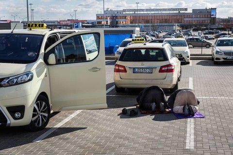 DEU Germany Germany Berlin Muslim taxi drivers pray in a car park outside Berlin-Schönefeld airport