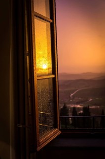 ITA Italy Castelfalfi View through a hotel window of the Tuscan countryside at sunset
