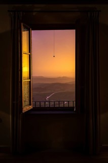 ITA Italy Castelfalfi View through a hotel window of the Tuscan countryside at sunset