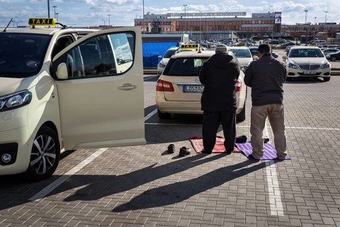 DEU Germany Germany Berlin Muslim taxi drivers pray in a car park outside Berlin-Schönefeld airport