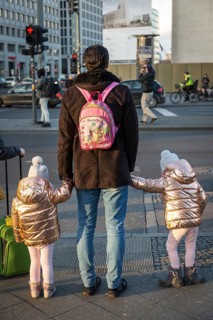 DEU Germany Germany Berlin A father holds hands with his twin daughters at a pedestrian crossing on