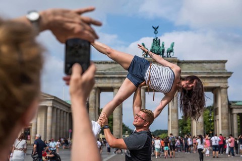 DEU Germany Germany Berlin A couple poses as a dancing figure in front of the Brandenburg Gate