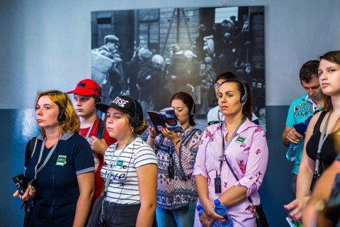 POL Poland Poland Auschwitz Visitors listen to their audio guide at the memorial site of the former