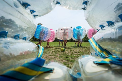 DEU Germany Germany Berlin A group of Dutch tourists playing bubblesoccer in a meadow in Volkspark