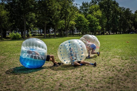 DEU Germany Germany Berlin A group of Dutch tourists playing bubblesoccer in a meadow in Volkspark
