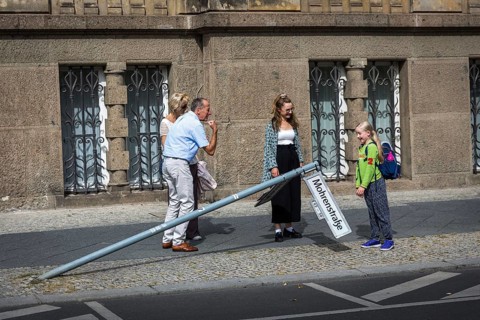 DEU Germany Germany Berlin A man shows a strong arm while a schoolgirl looks at a knocked down