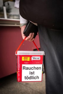 DEU Germany Germany Berlin Man with tobacco box at a market in Buckow