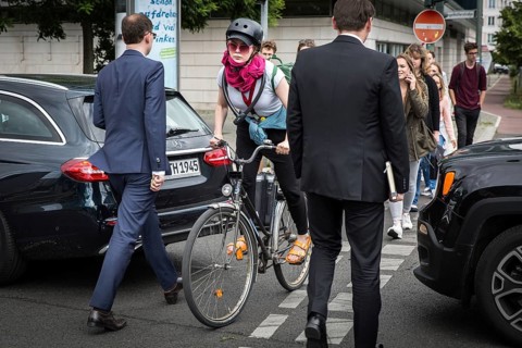 DEU Germany Germany Berlin Cyclist and pedestrian queue through heavy traffic on