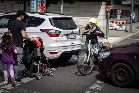 DEU Germany Germany Berlin Cyclist and pedestrian queue through heavy traffic on