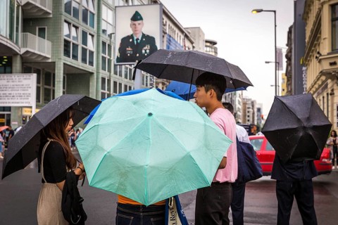 DEU Germany Germany Berlin Tourists with umbrellas at Checkpoint Charlie