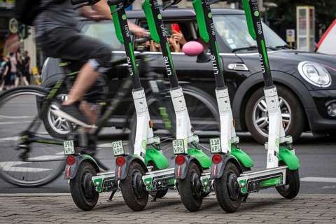 DEU Germany Germany Berlin Traffic passes parked e-scooters on Karl-Liebknecht-Str