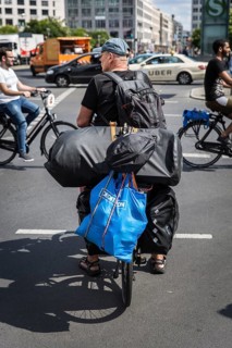 DEU Germany Germany Berlin Cyclist with numerous pieces of luggage on his bike passes Potsdamer