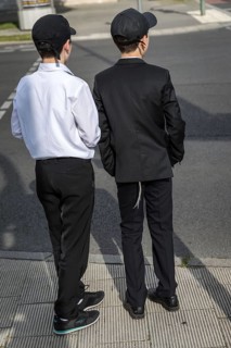 DEU Germany Germany Berlin Two boys in suits with baseball caps at a pedestrian crossing
