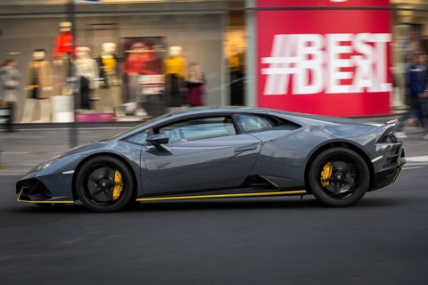 DEU Germany Germany Berlin A Lamborghini passes a shop window advert on the Kudamm