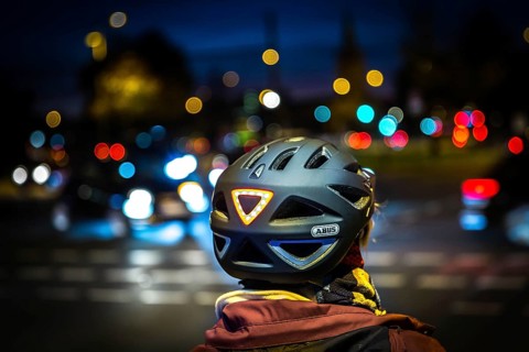 DEU Germany Germany Berlin A cyclist wearing a helmet with LED light waits at a traffic light on