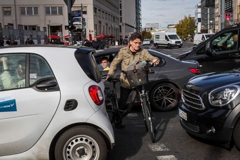 DEU Germany Germany Berlin Cyclists squeeze between stationary cars on Potsdamer Platz