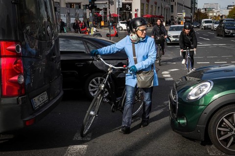 DEU Germany Germany Berlin Cyclists squeeze between stationary cars on Potsdamer Platz