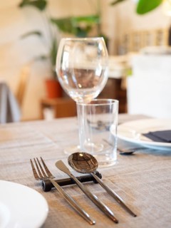 Elegant restaurant table arranging cutlery, plates, and glasses on a linen tablecloth