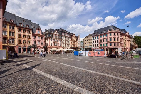 Square made of paving stones and marble slabs with pattern, row of houses, reconstructed historic