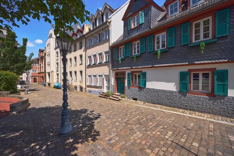 Historic building, houses, dormers, façade with windows, stairs and door, paving stone walkway,