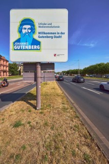Welcome to Gutenberg City, tourist sign, roads, lanes, central island, lantern, trees, lawn, blue