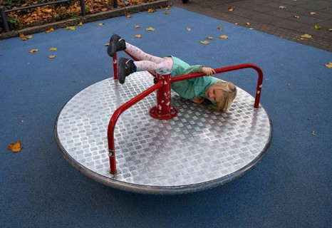 Outdoor shot, little girl, child, 4 years, blonde, playing, gymnastics on carousel, children's