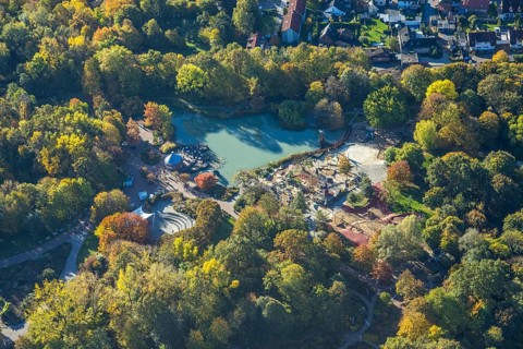 Aerial view, lake and autumn trees in Maximilianpark, children's playground and open-air stage,